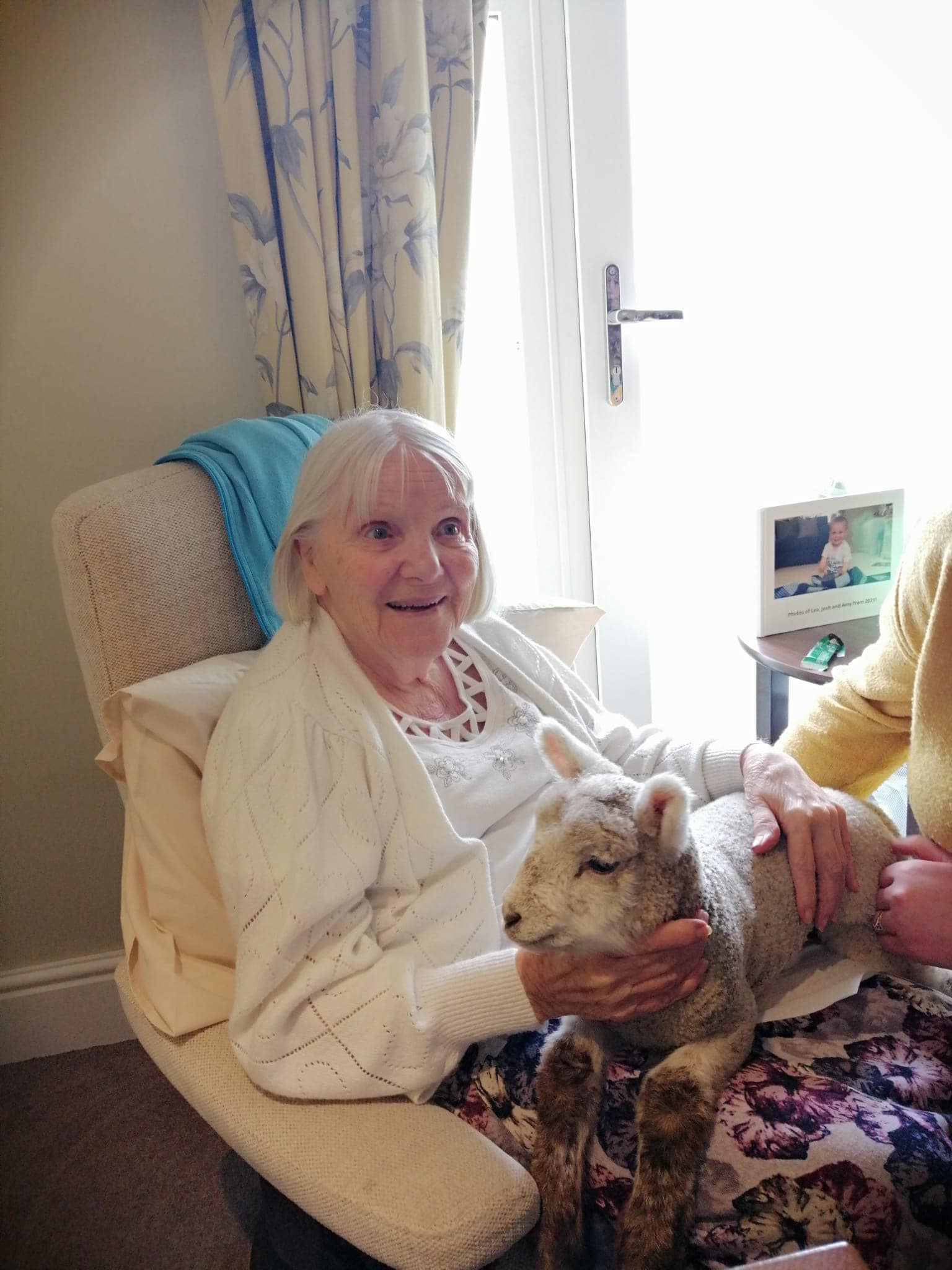 A resident with a lamb at The Amwell Care Home