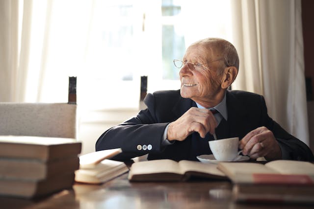 elderly man enjoying a hot drink looking into the distance