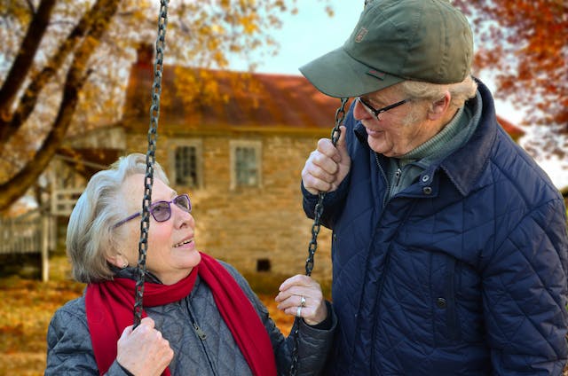 elderly couple on a swing looking at each other