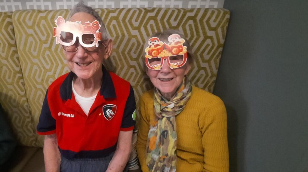 residents with chinese new year glasses on sat together on a sofa