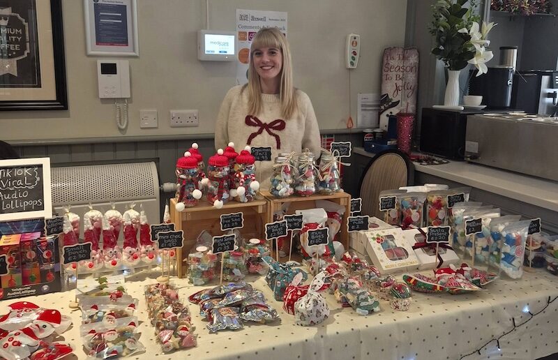 one of our team stood in front of a table full of sweets and treats for visitors