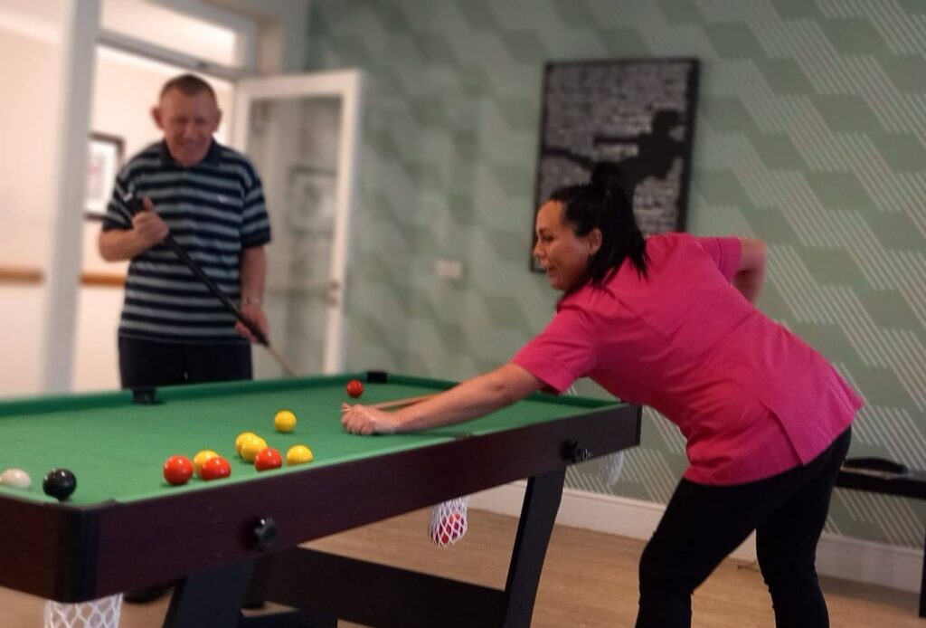 carer playing pool with a resident