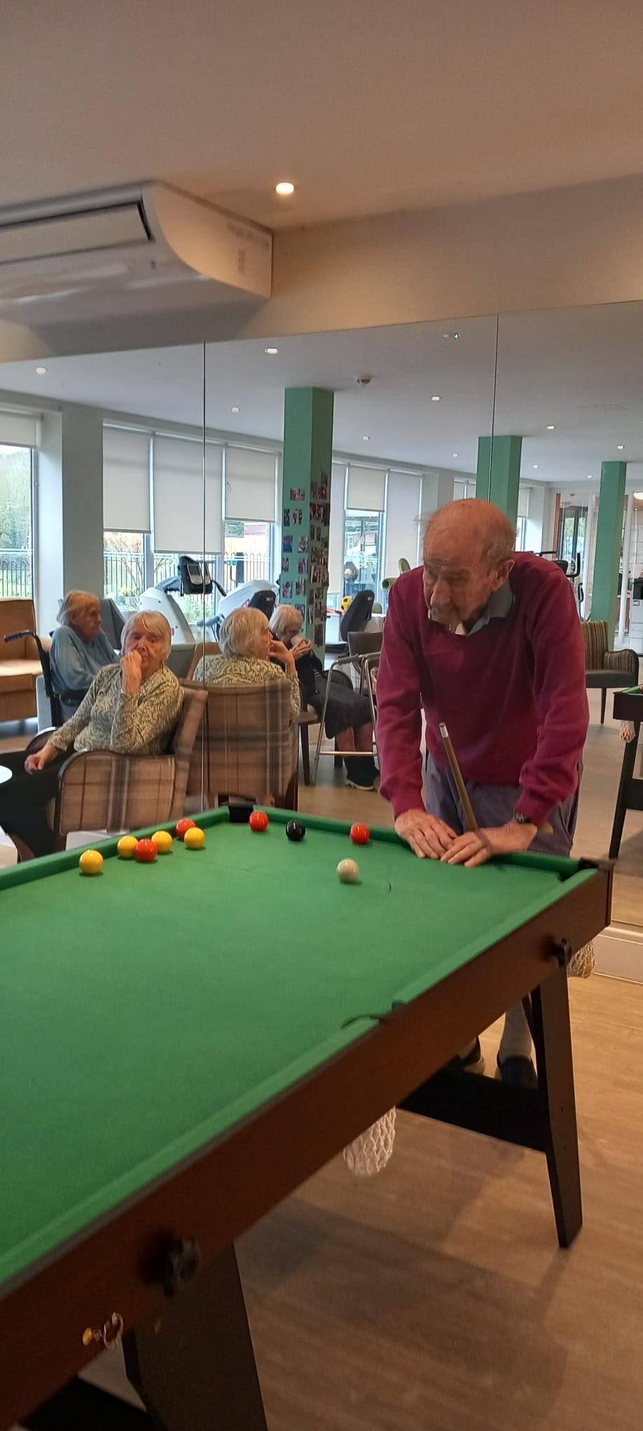 resident standing next to the pool table