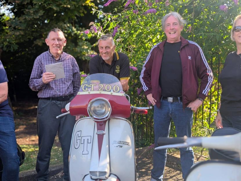 older men stood by a scooter