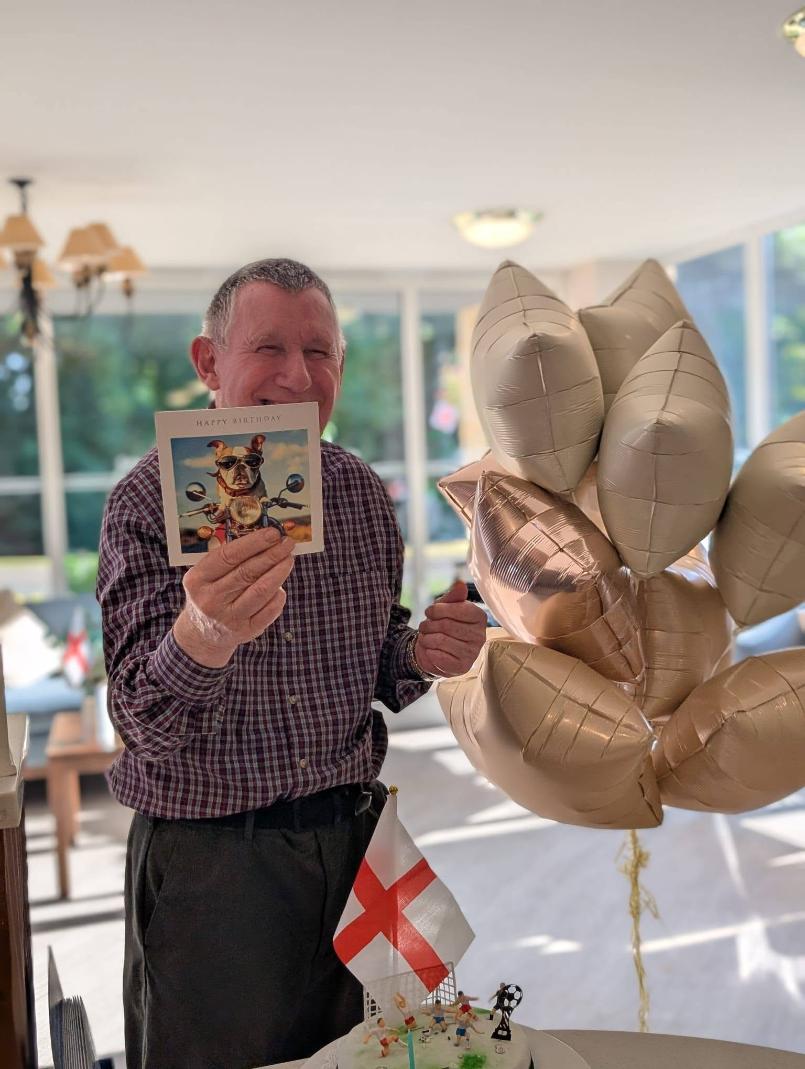 an older man holding up a birthday card