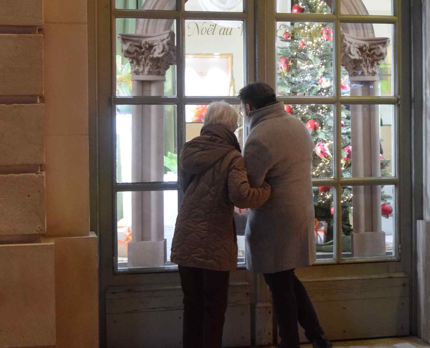 resident with carer looking at shop window christmas decorations